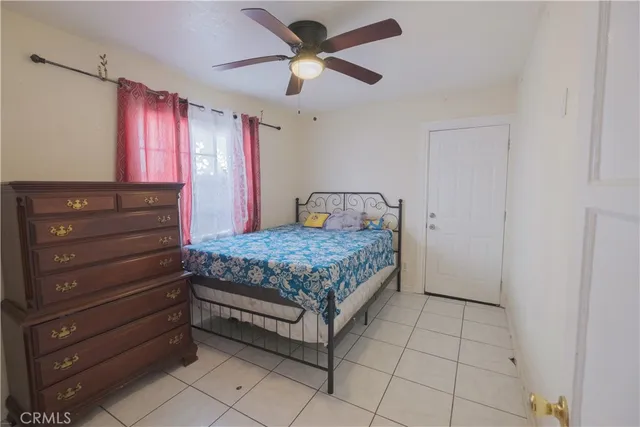 a bedroom with a large bed and a ceiling fan