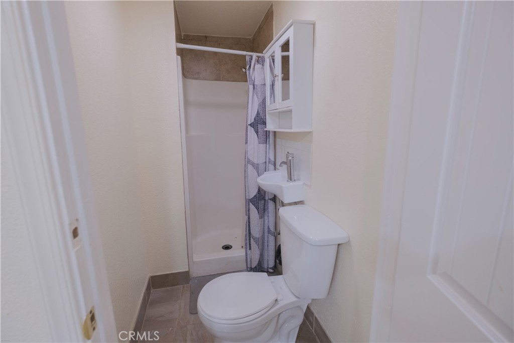 2534 East 127th Street Compton, CA 90222 - Photo 16 of 22 a white toilet sitting next to a shower curtain