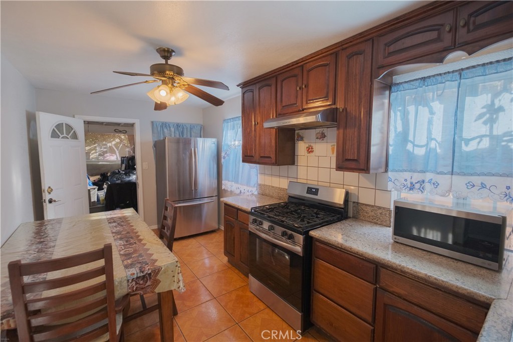 2534 East 127th Street Compton, CA 90222 - Photo 3 of 22 a kitchen with stainless steel appliances granite countertop a stove refrigerator and microwave