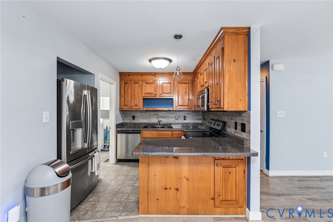 6338 Oak Drive Quinton, VA 23141 - Photo 7 of 25 a kitchen with stainless steel appliances granite countertop a sink a stove and a refrigerator