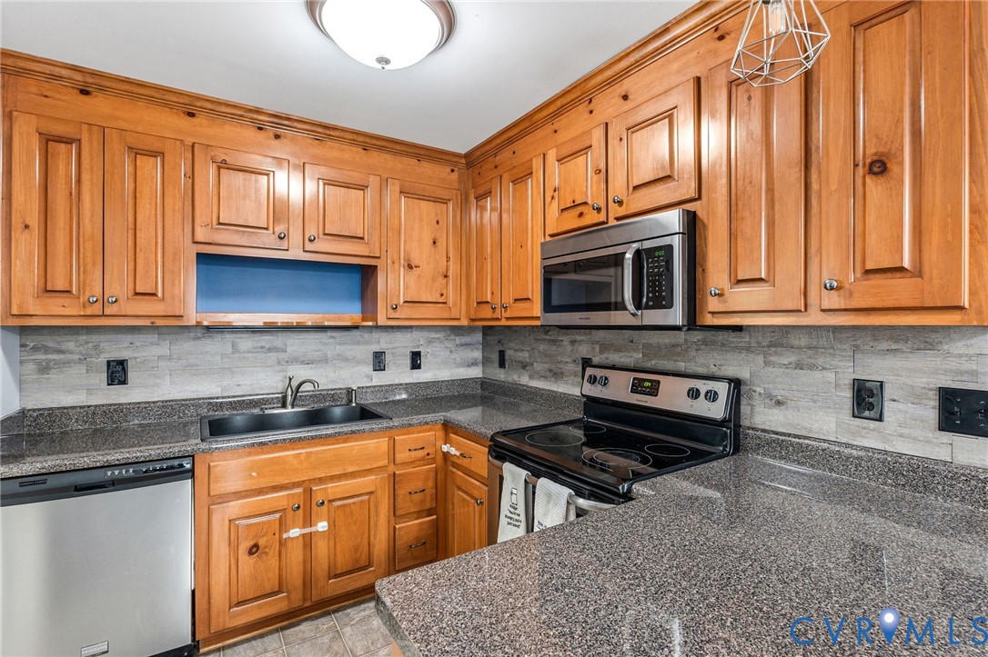 6338 Oak Drive Quinton, VA 23141 - Photo 9 of 25 a kitchen with stainless steel appliances granite countertop a stove a sink and a microwave