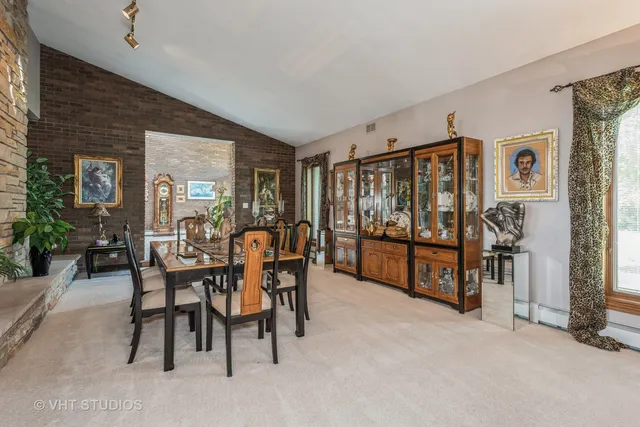 a dining room with furniture and floor to ceiling window