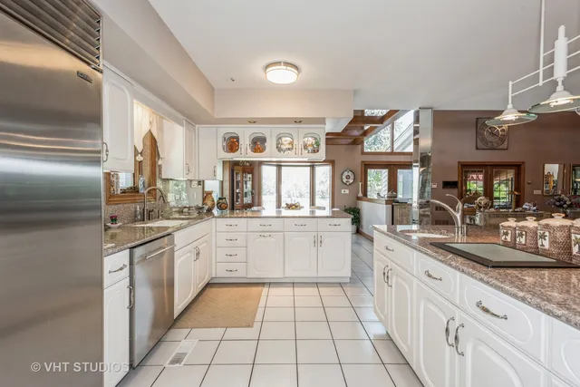 a kitchen with stainless steel appliances granite countertop a sink and dishwasher a oven with white cabinets