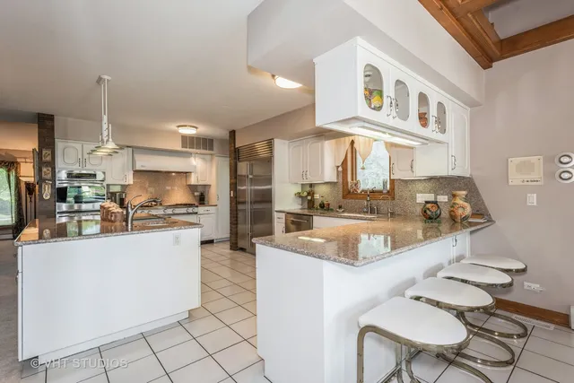a kitchen with stainless steel appliances granite countertop a sink and a refrigerator