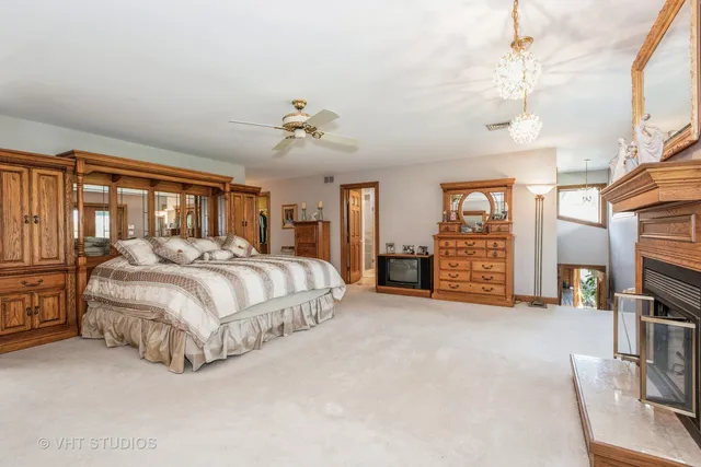 a spacious bedroom with a large bed and a chandelier