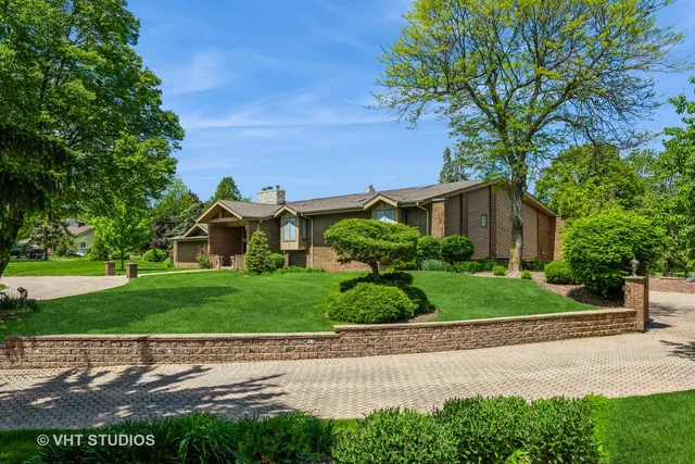 a front view of a house with a yard and potted plants