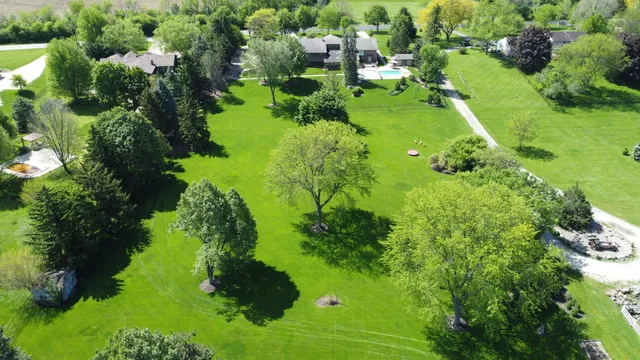 an aerial view of residential houses with outdoor space and trees all around