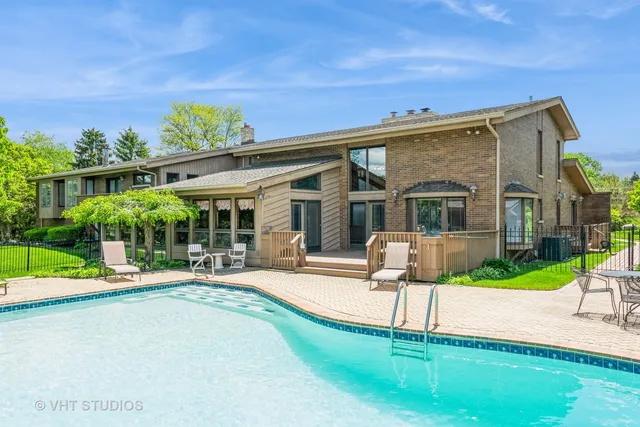 a patio with a table and chairs and potted plants