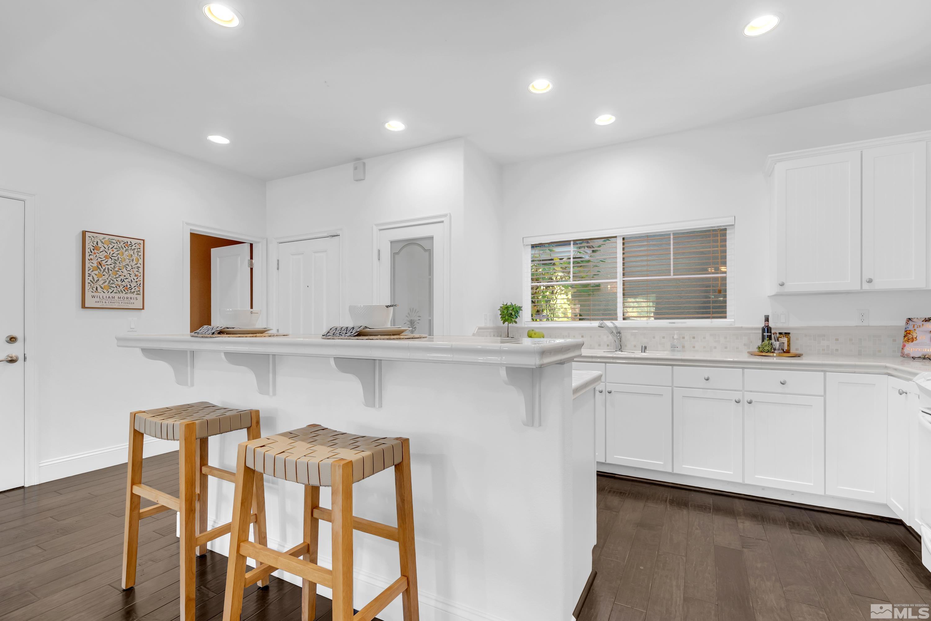 1410 Waterloo Drive Reno, NV 89509 - Photo 9 of 37 a kitchen with white cabinets and chairs
