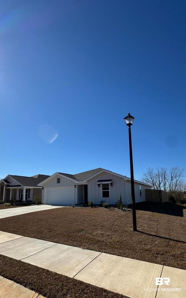 23933 Signor Place Daphne, AL 36526 - Photo 24 of 24 View of front facade with an attached garage, board and batten siding, and concrete driveway