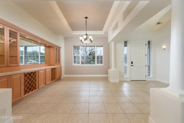 a view of a refrigerator in kitchen and an empty room