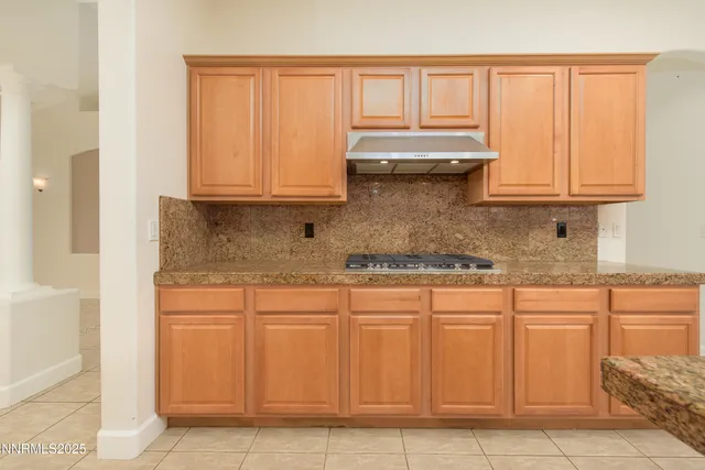 a view of a livingroom with a fireplace a ceiling fan and windows
