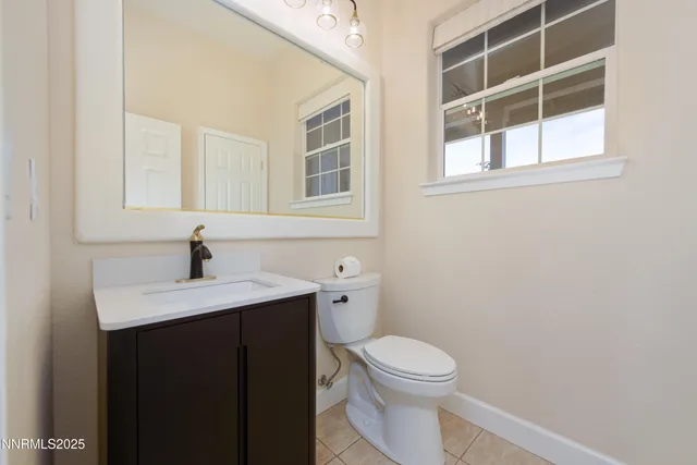 an empty room with chandelier fan and windows
