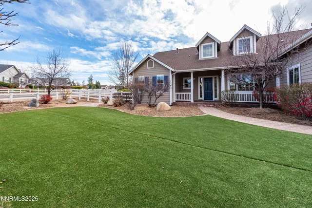a front view of a house with a garden and sitting area