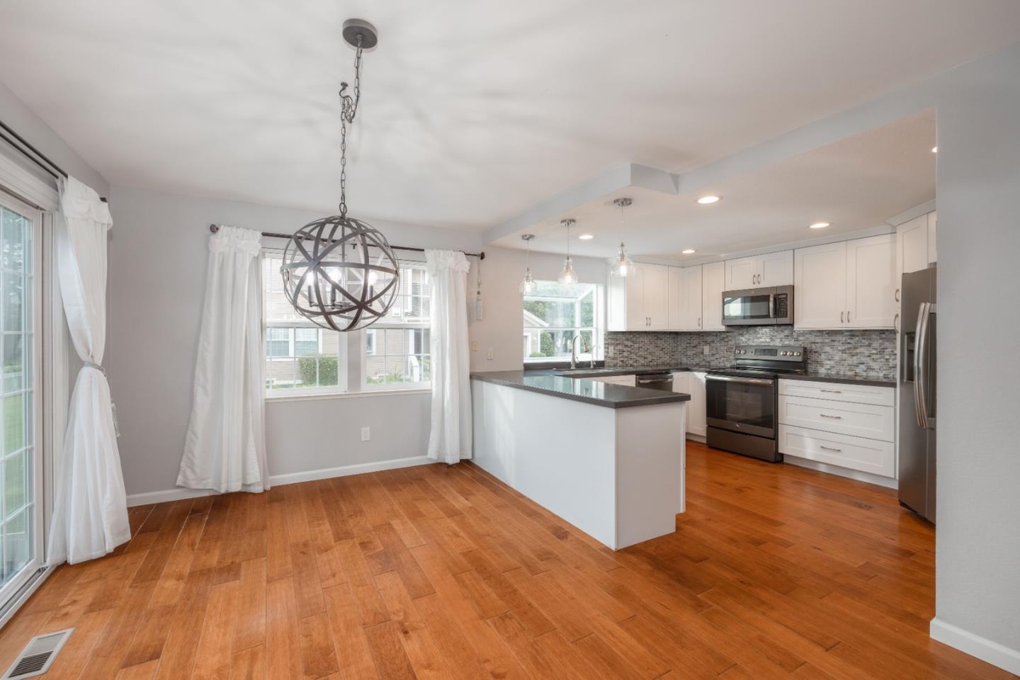 9 Merion Road Half Moon Bay, CA 94019 - Photo 4 of 14 a kitchen with stainless steel appliances granite countertop wooden floors refrigerator and window