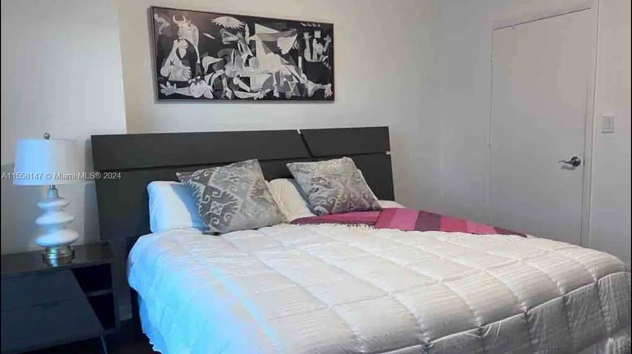 Downtown Miami Miami, FL 33132 - Photo 6 of 18 a bedroom with a bed and painting on the wall