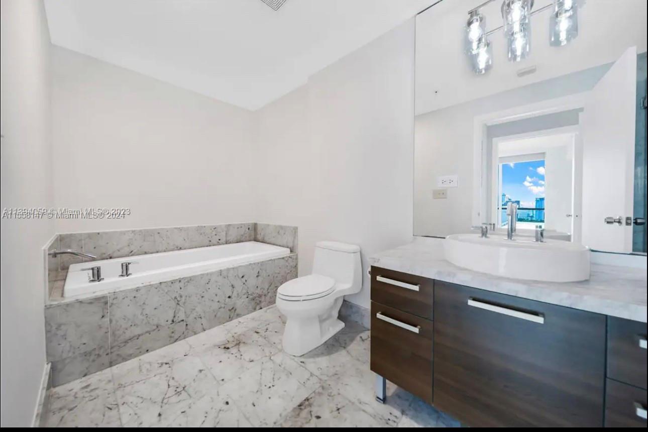 Downtown Miami Miami, FL 33132 - Photo 7 of 18 a bathroom with a granite countertop toilet sink and mirror