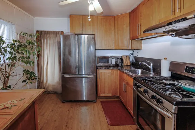 a kitchen with granite countertop a stove sink and cabinets