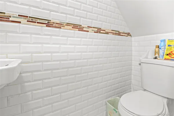 a white toilet sitting next to a white cabinet