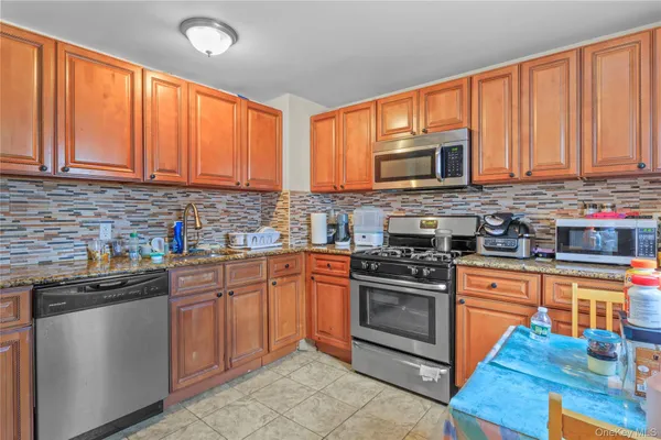 a kitchen with stainless steel appliances granite countertop wooden cabinets a stove top oven a sink and dishwasher