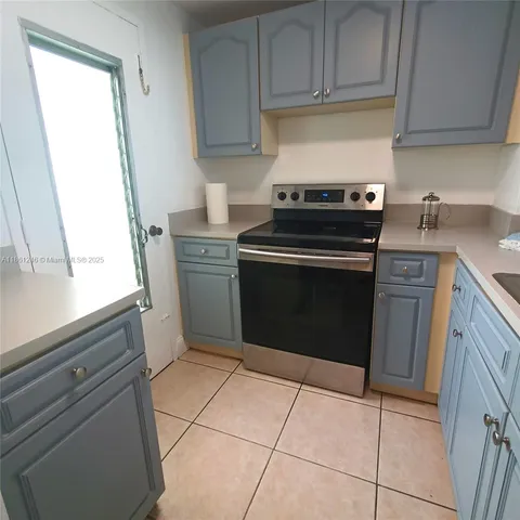 a kitchen with a stove top oven and cabinets