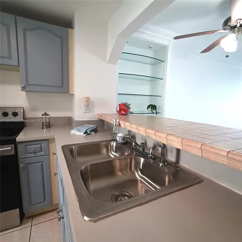 a kitchen with a sink and a stove top oven with wooden floor