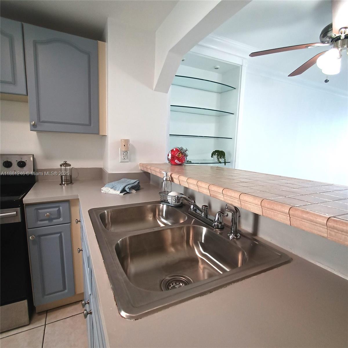 8000 Harding Avenue, Unit 3B Miami Beach, FL 33141 - Photo 12 of 30 a kitchen with a sink and a stove top oven with wooden floor