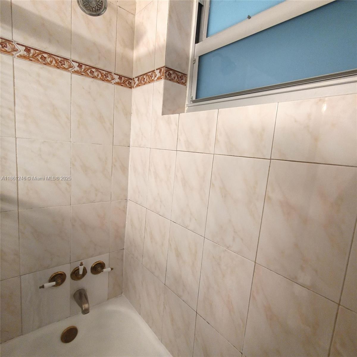 8000 Harding Avenue, Unit 3B Miami Beach, FL 33141 - Photo 25 of 30 a bathroom with a shower and a bathtub