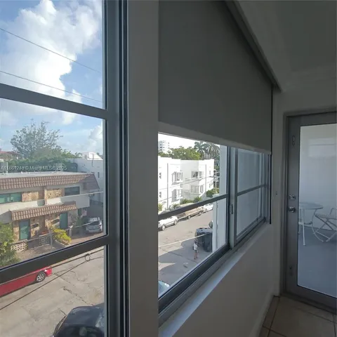 a view of a glass door and a car parked from a window