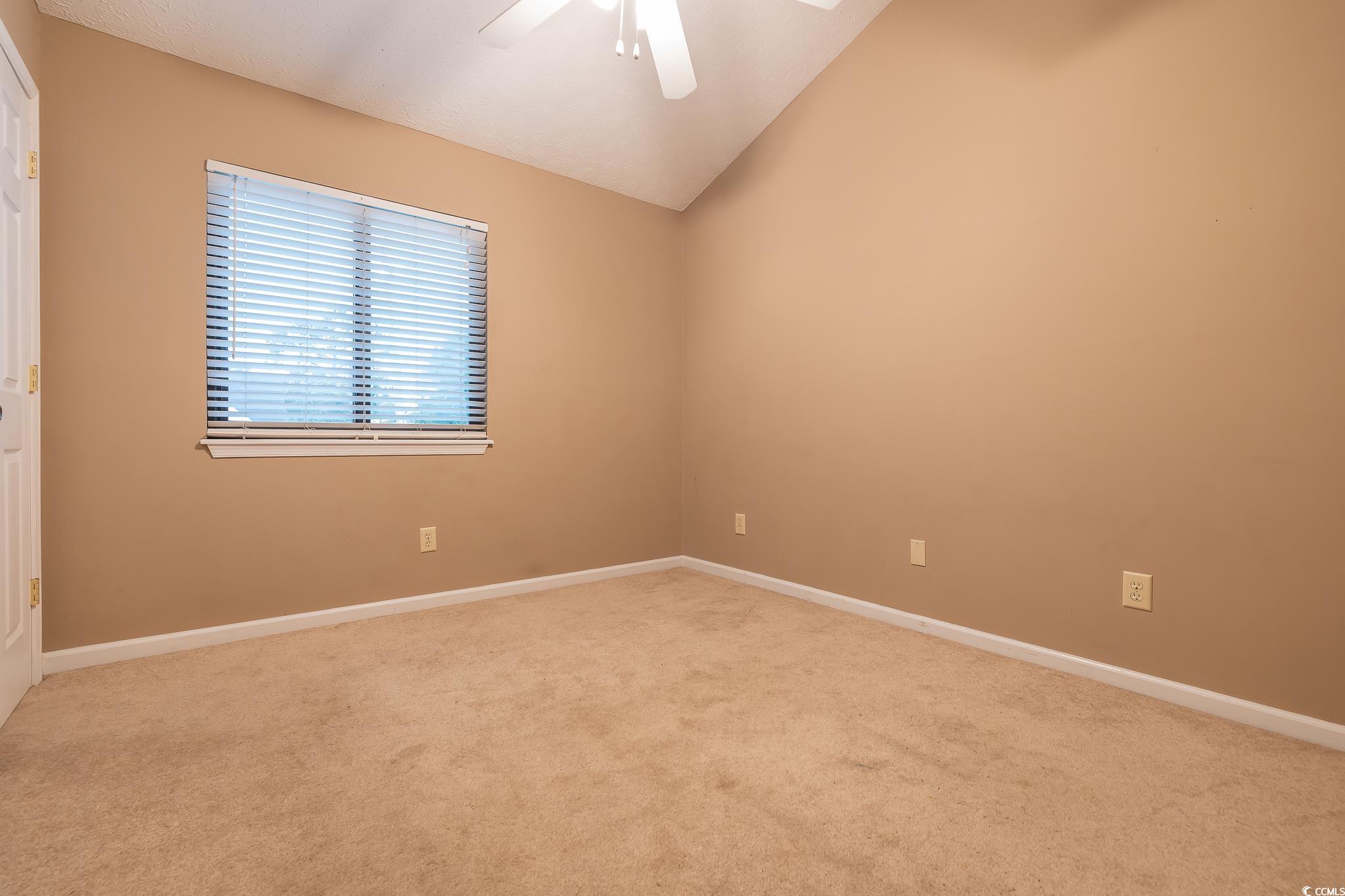 620 15th Avenue South, Unit 89 Surfside Beach, SC 29575 - Photo 13 of 14 Unfurnished room featuring lofted ceiling, carpet, and ceiling fan