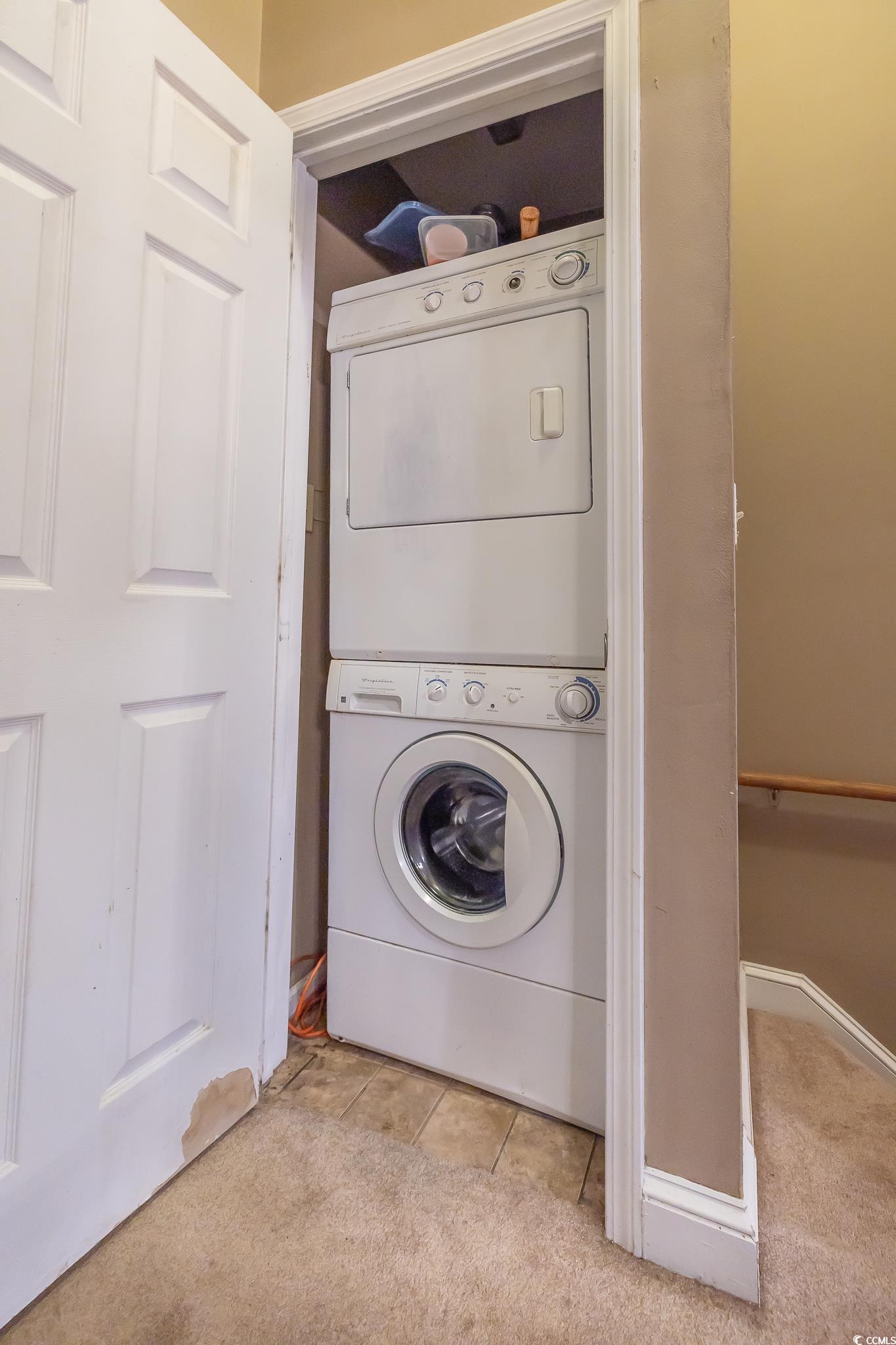 620 15th Avenue South, Unit 89 Surfside Beach, SC 29575 - Photo 9 of 14 Laundry area with stacked washer / drying machine, light colored carpet, and light tile patterned floors
