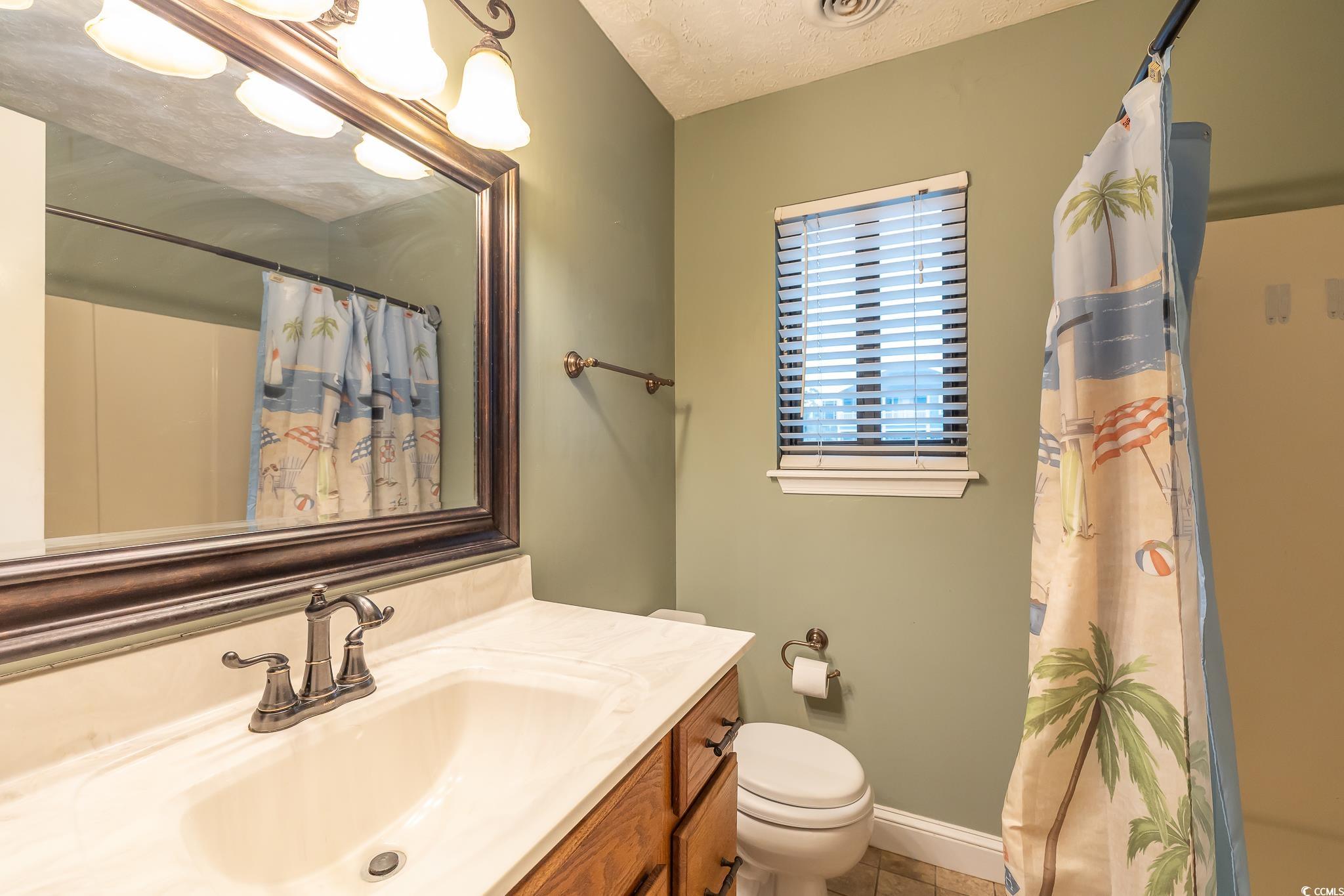 620 15th Avenue South, Unit 89 Surfside Beach, SC 29575 - Photo 10 of 14 Full bath with vanity, a textured ceiling, and a shower with curtain