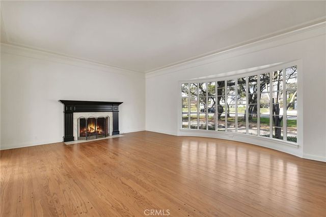 wooden floor fireplace and windows in an empty room
