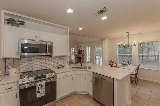 a living room with furniture kitchen view and a large window