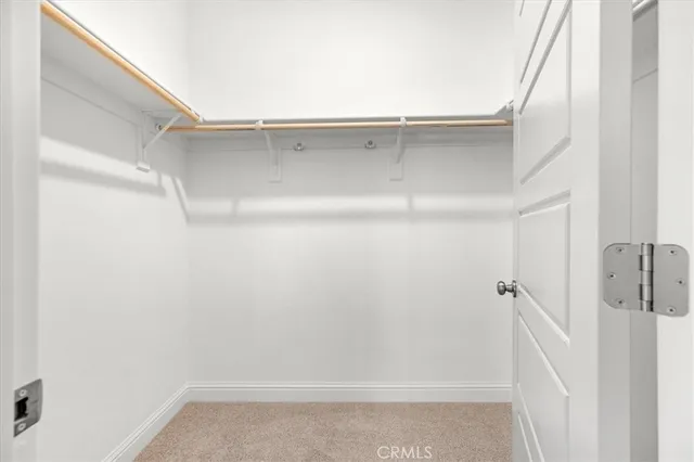 a view of kitchen with refrigerator and white cabinets