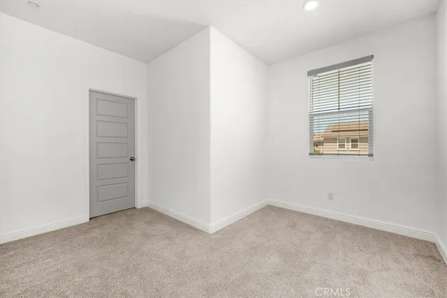 an empty room with a fireplace and windows