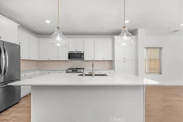 a large white kitchen with white cabinets and a wooden floor