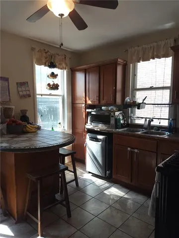 a kitchen with a stove a sink a window and cabinets