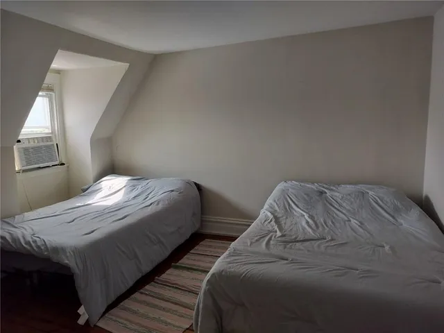 a bed sitting in a bedroom next to a window