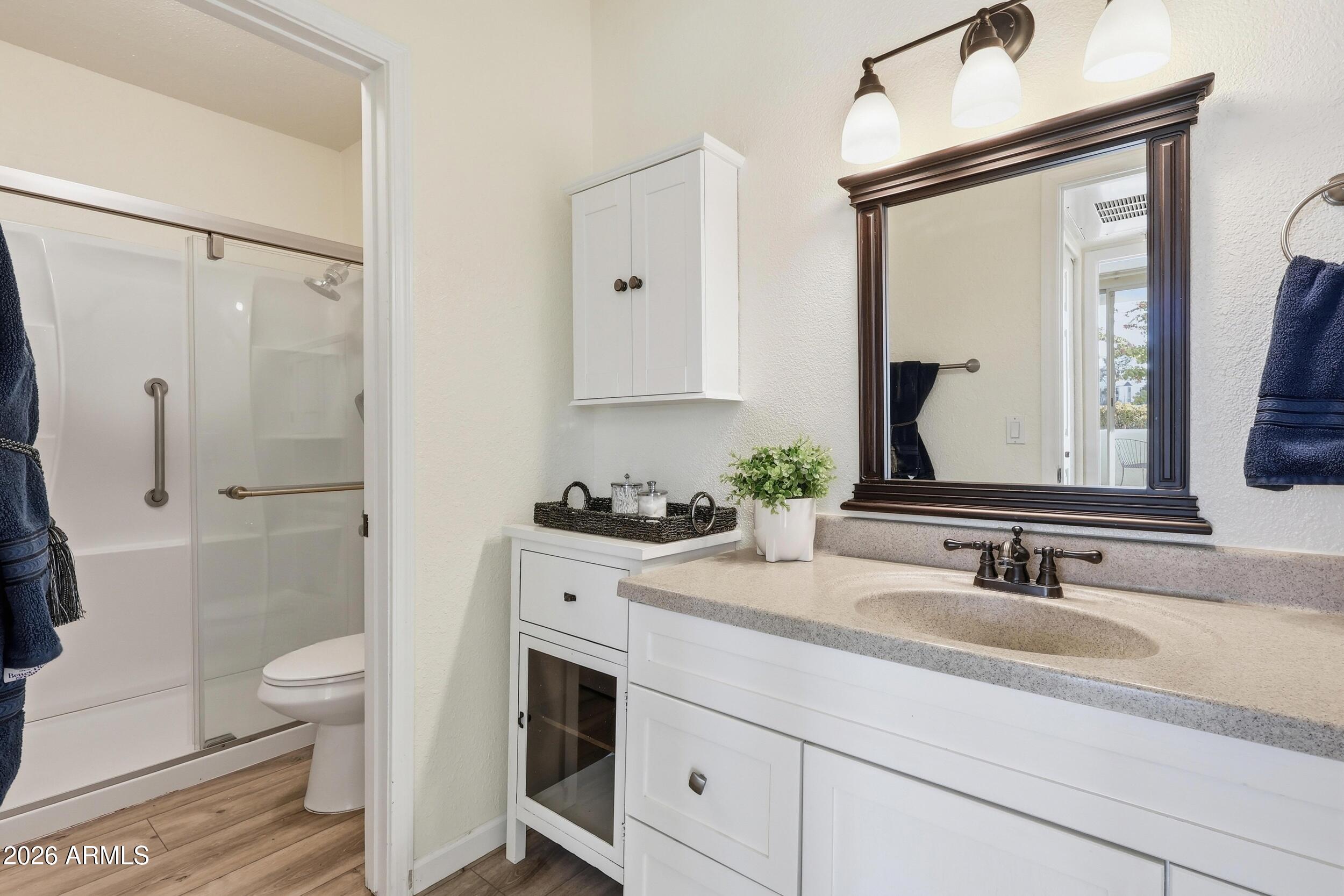 1825 West Ray Road, Unit 1018 Chandler, AZ 85224 - Photo 13 of 46 a bathroom with a sink vanity granite toilet and a mirror