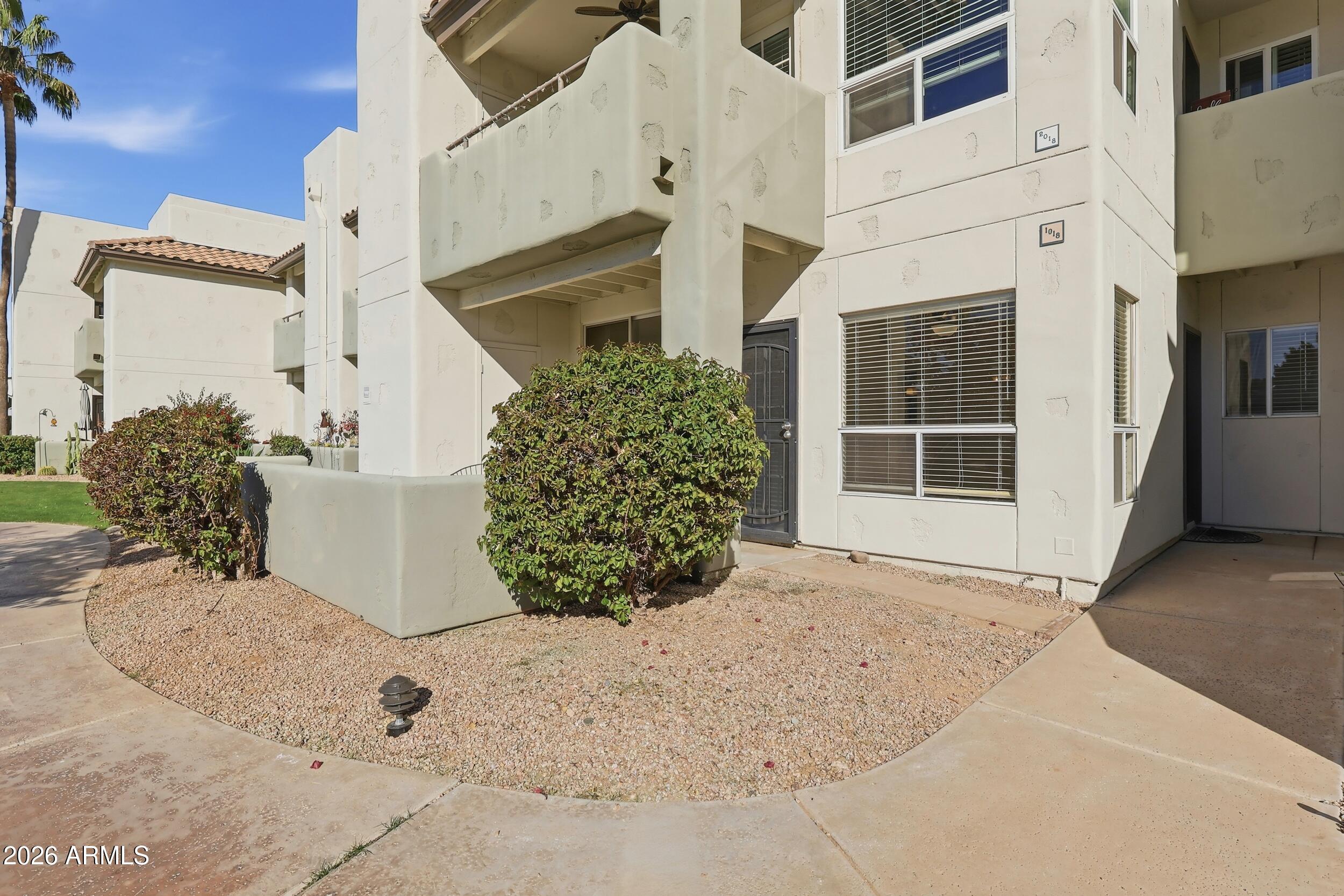 1825 West Ray Road, Unit 1018 Chandler, AZ 85224 - Photo 40 of 46 front view of a house with a potted plant and floor to ceiling windows