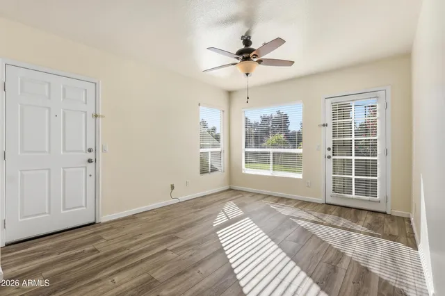 a view of a livingroom with wooden floor and a ceiling fan