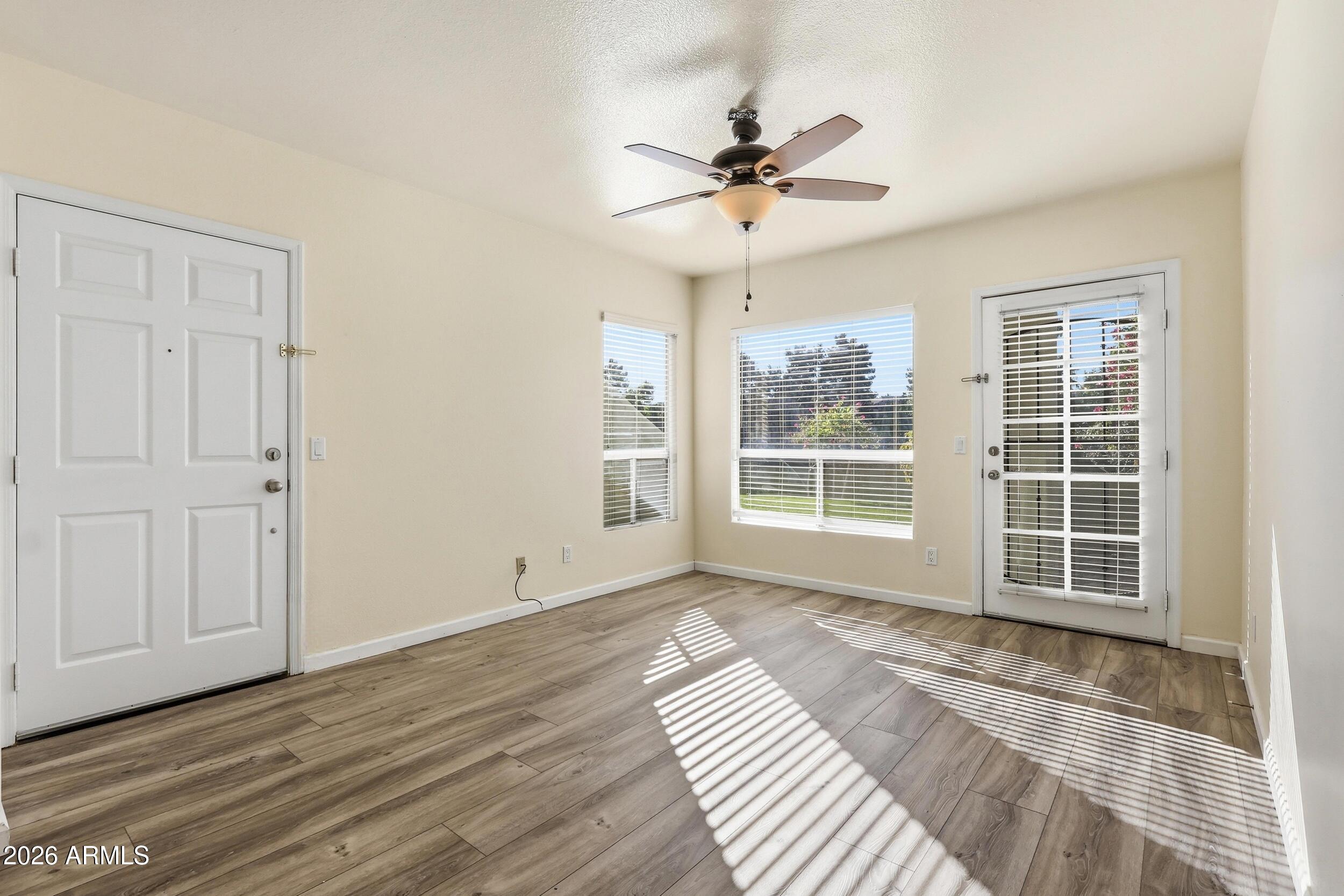 1825 West Ray Road, Unit 1018 Chandler, AZ 85224 - Photo 4 of 46 a view of a livingroom with wooden floor and a ceiling fan