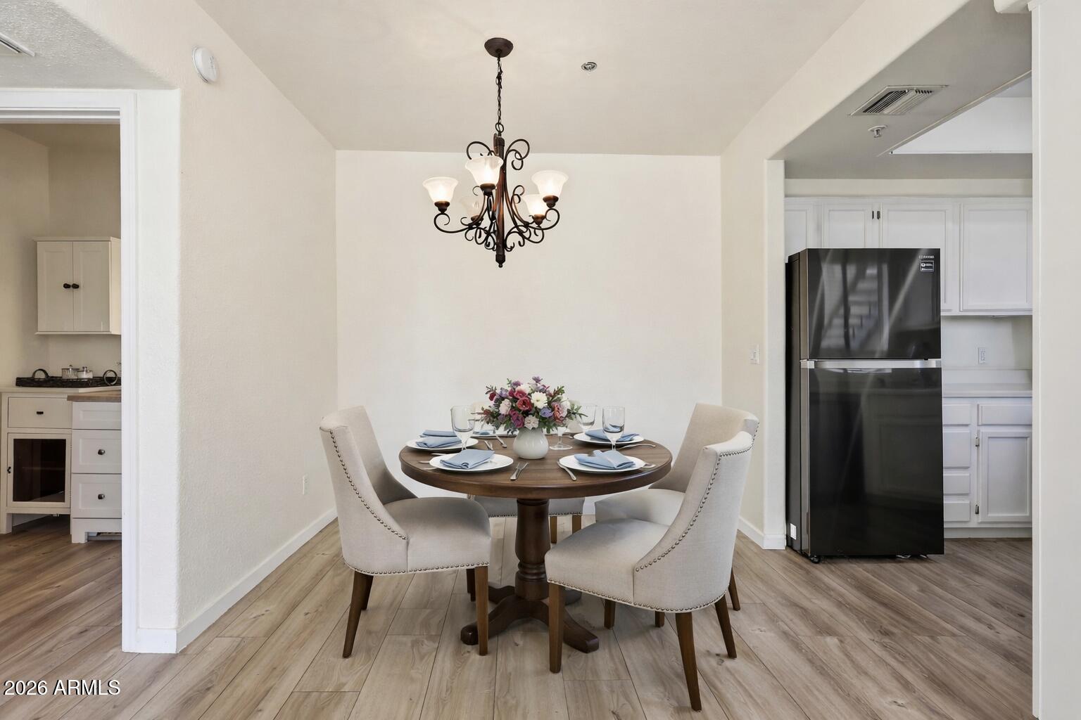 1825 West Ray Road, Unit 1018 Chandler, AZ 85224 - Photo 5 of 46 a view of a dining room with furniture wooden floor and a chandelier