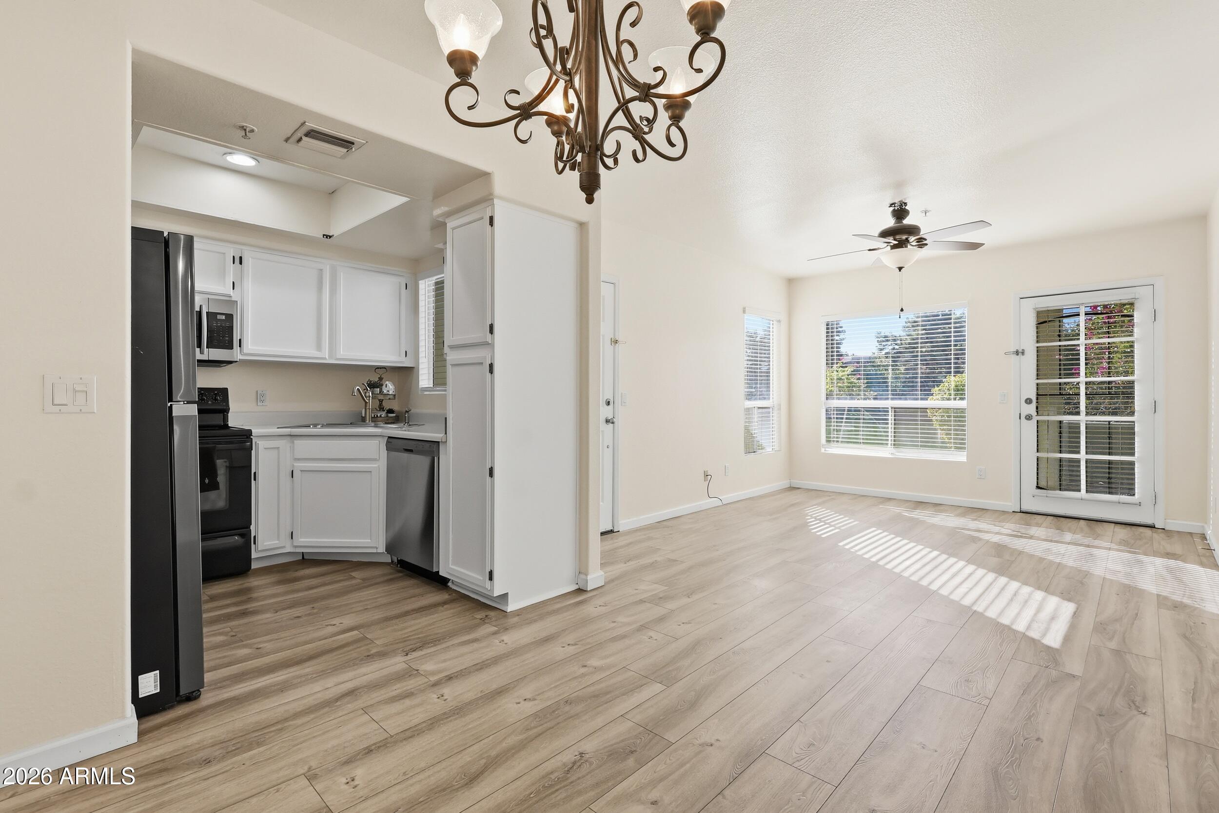 1825 West Ray Road, Unit 1018 Chandler, AZ 85224 - Photo 7 of 46 a view of a kitchen with a sink and dishwasher a refrigerator with wooden floor