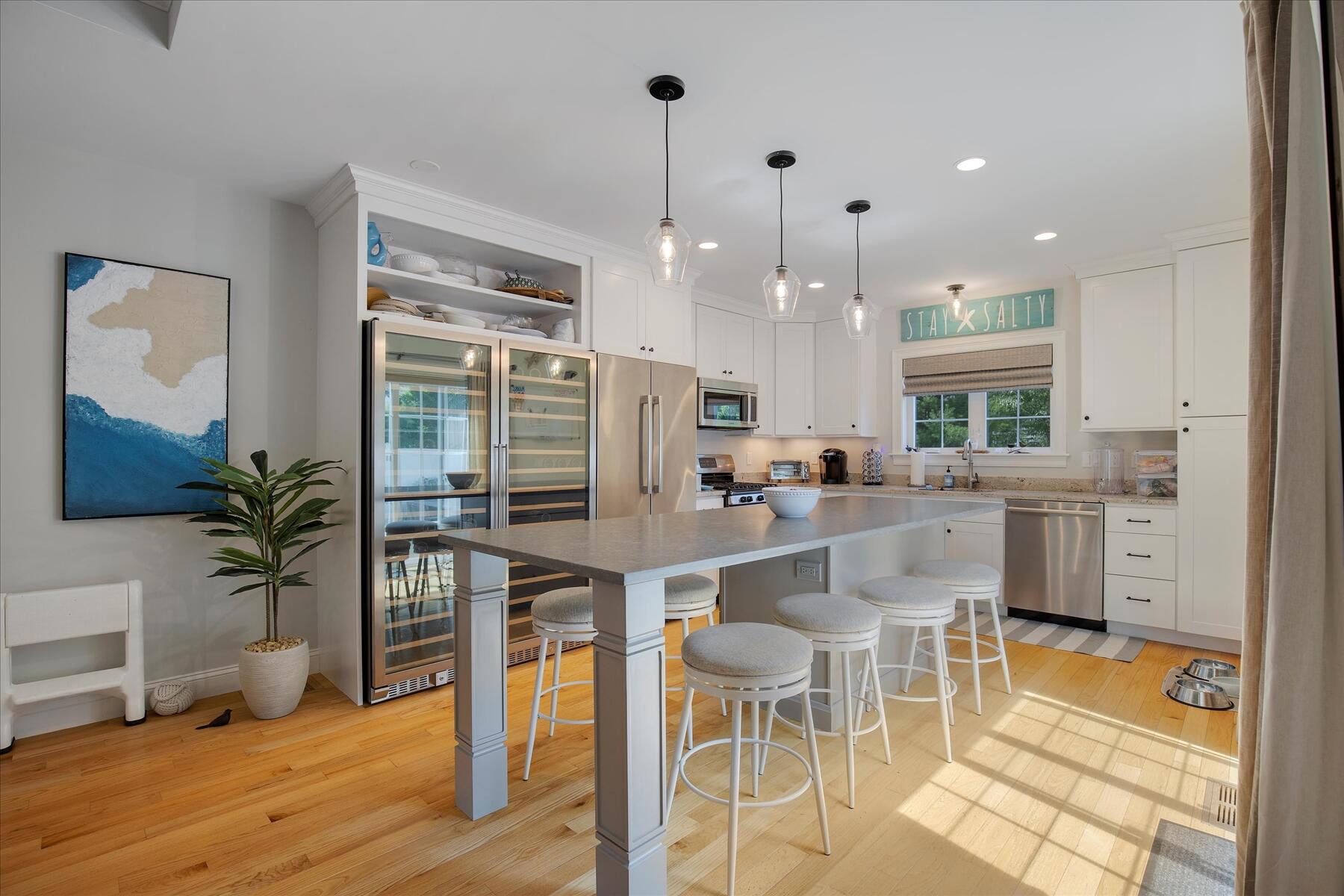 21 Saltwater Circle Mashpee, MA 02649 - Photo 6 of 40 a kitchen with stainless steel appliances kitchen island granite countertop a refrigerator a stove a dining table and chairs with wooden floor