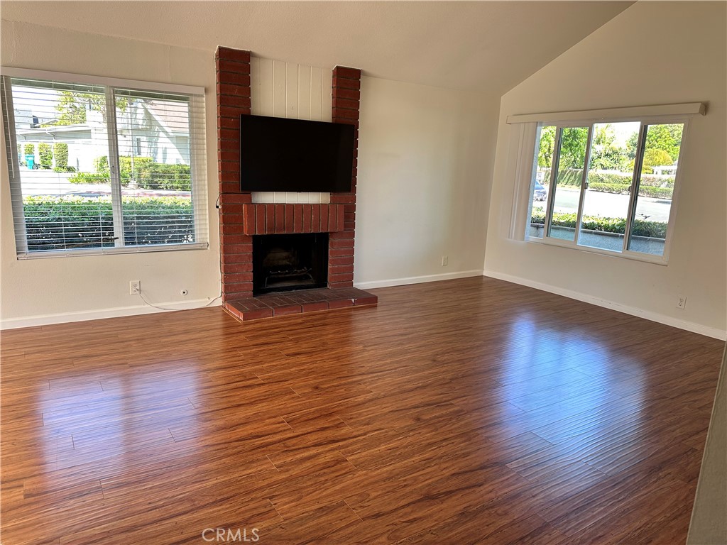 1 Sunflower Irvine, CA 92604 - Photo 5 of 19 an empty room with wooden floor a fireplace and windows
