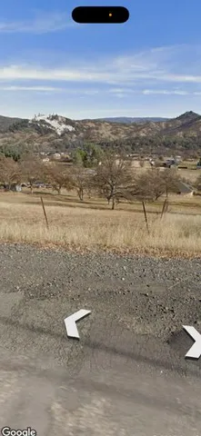 a view of a house with backyard and wooden fence
