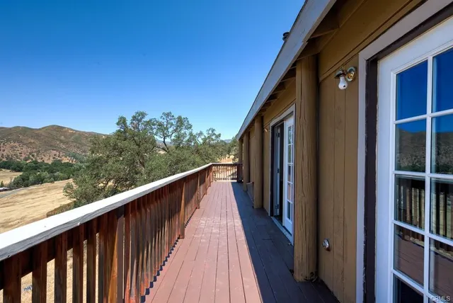 a view of a balcony with wooden floor and fence