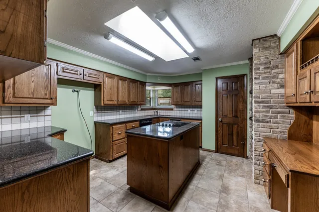 a kitchen with granite countertop a stove and a refrigerator
